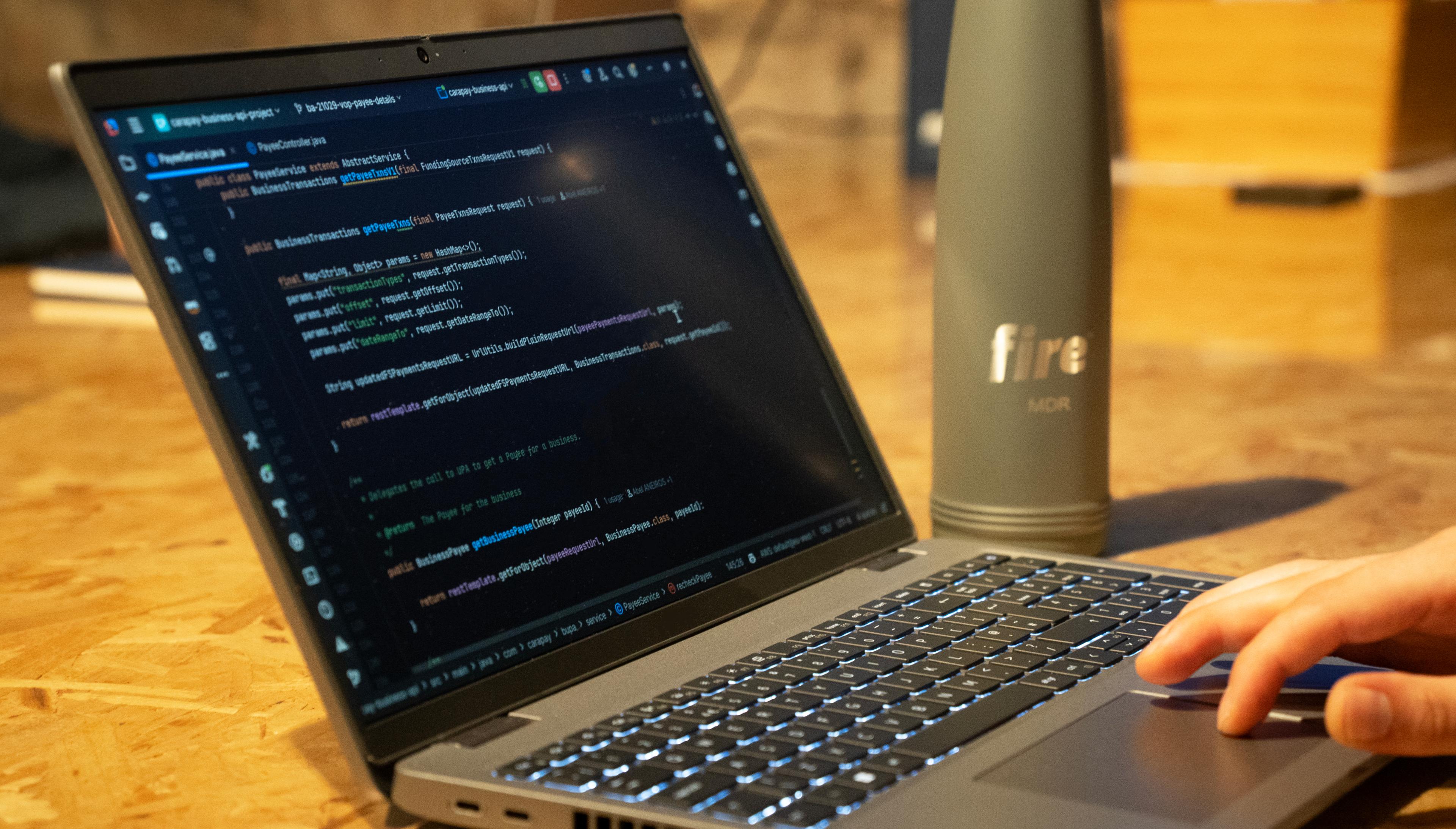 Laptop on wooden table and cup with Fire’s logo.